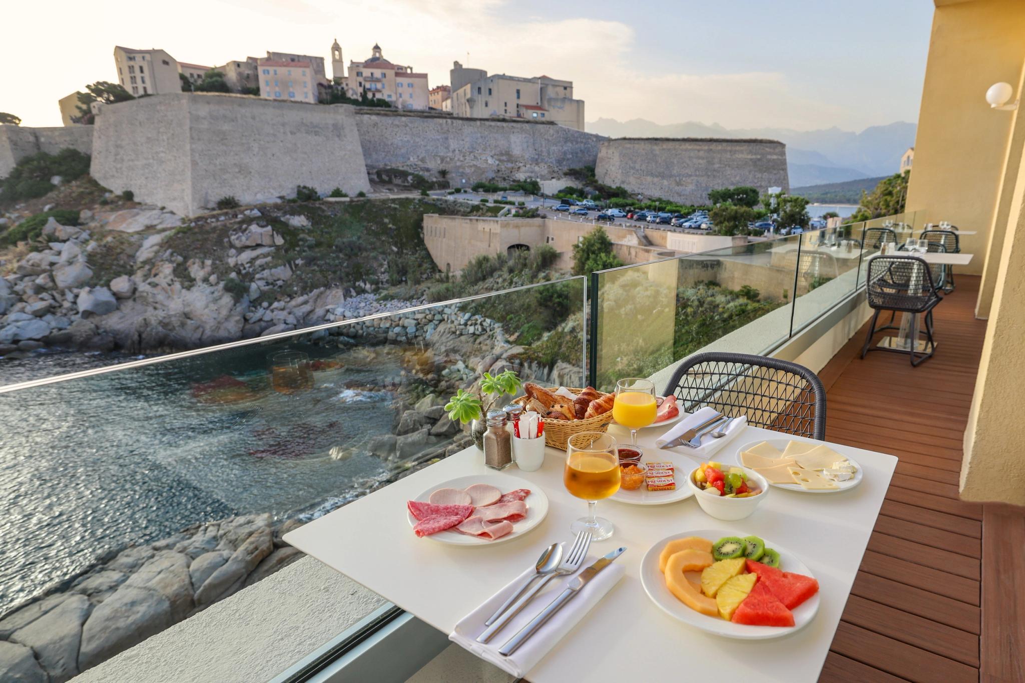 Table et petit-déjeuner varié servi dans le restaurant panoramique de l'Hôtel Saint-Christophe à Calvi