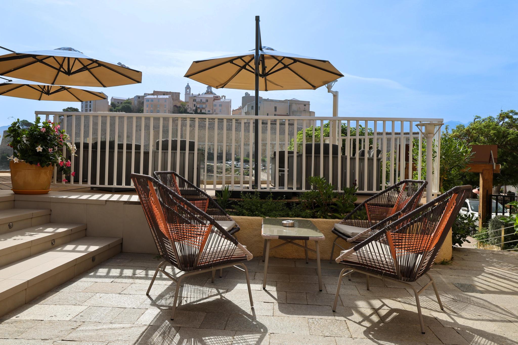 Espace bar avec vue sur la mer à l'Hôtel Saint-Christophe en Balagne, idéal pour savourer un cocktail au coucher du soleil