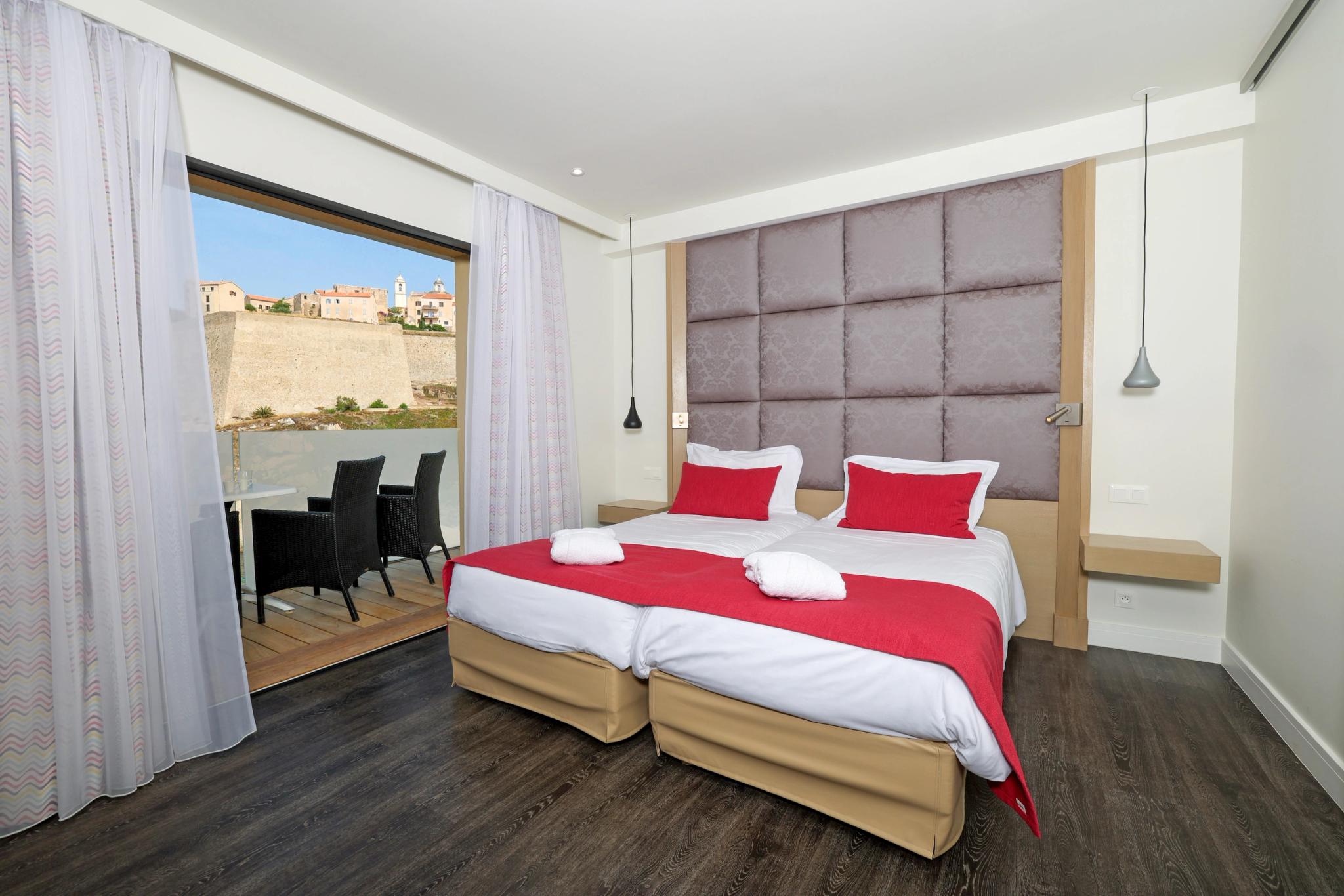 Chambre triple spacieuse à l’Hôtel Saint-Christophe à Calvi avec vue frontale sur la Méditerranée