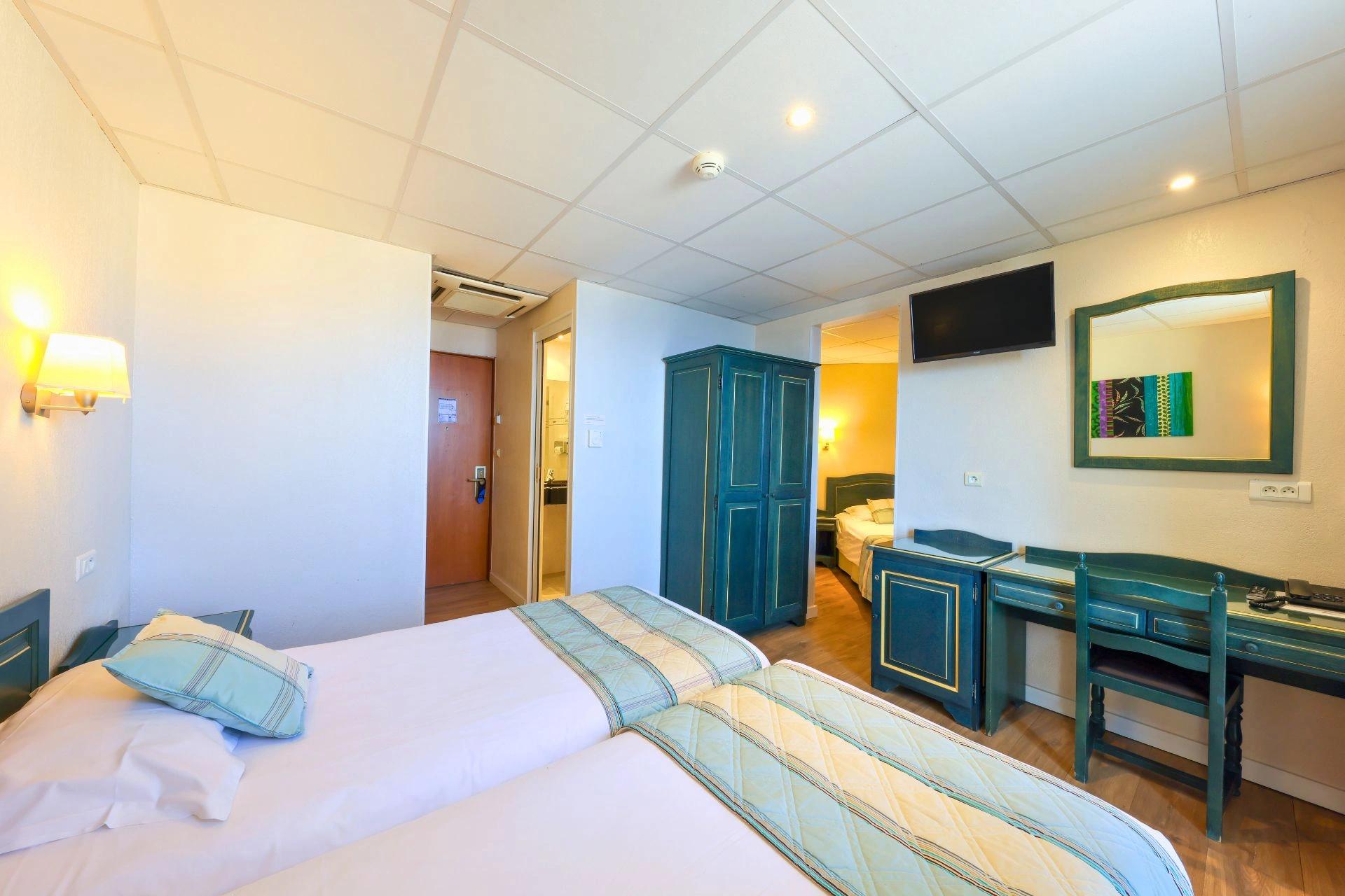 Chambre triple fonctionnelle avec mobilier pratique et vue mer partielle en Haute-Corse