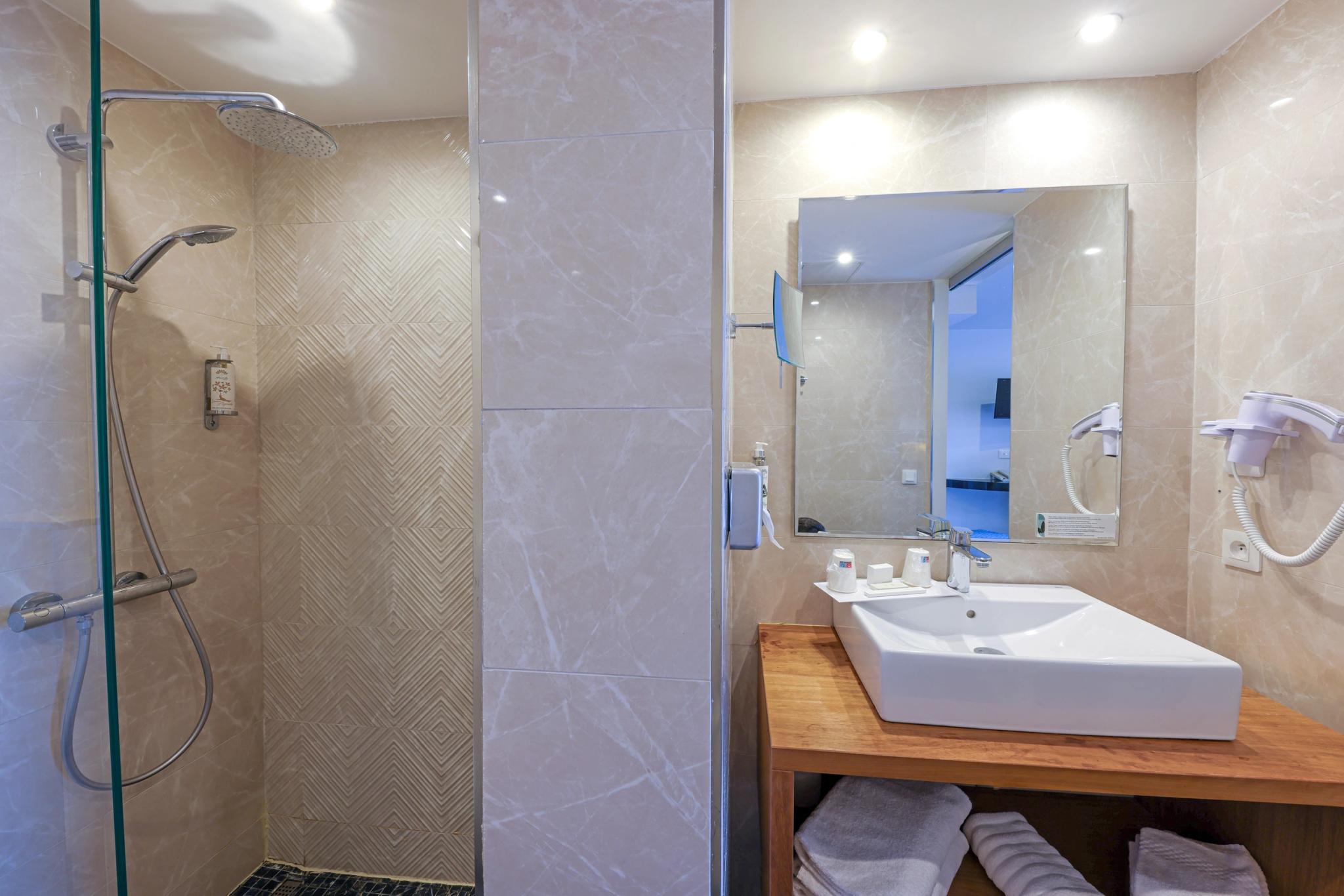 Salle de bain claire avec douche vitrée à Calvi