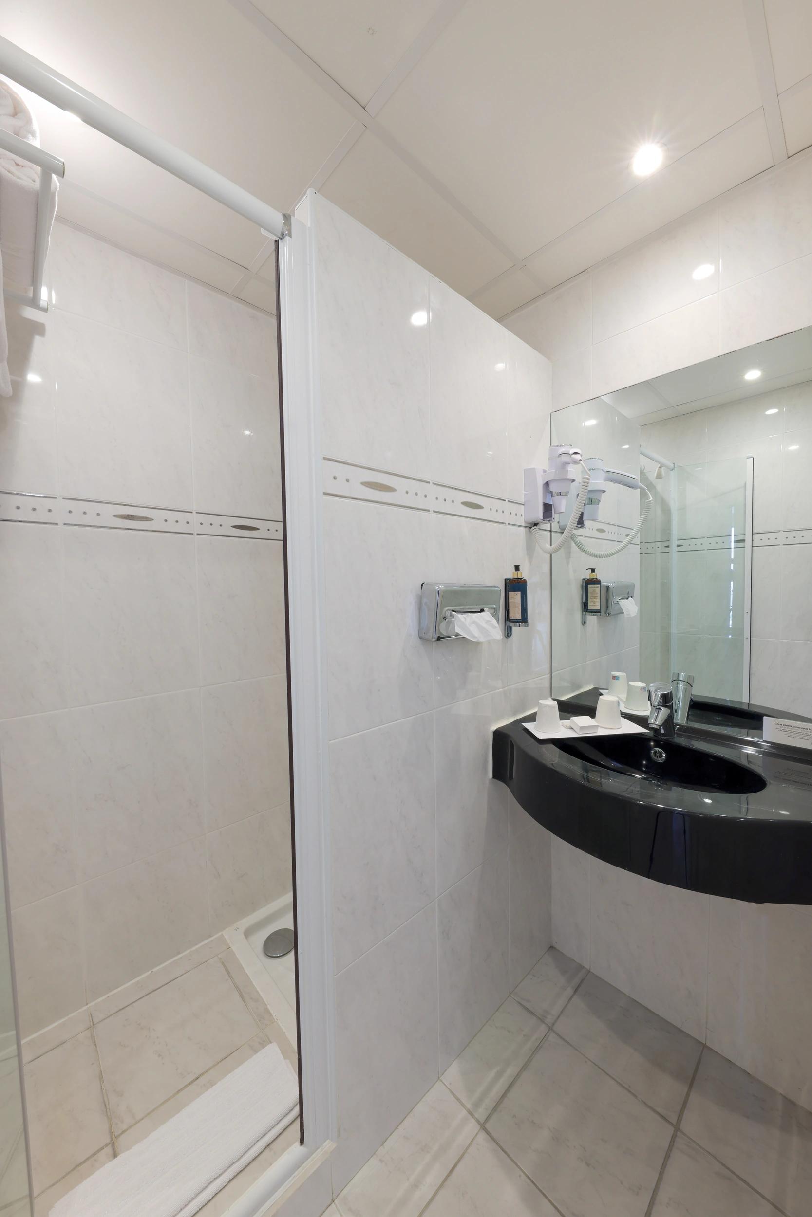 Salle de bain privative avec douche dans une chambre Standard vue jardin à l’Hôtel Saint-Christophe à Calvi
