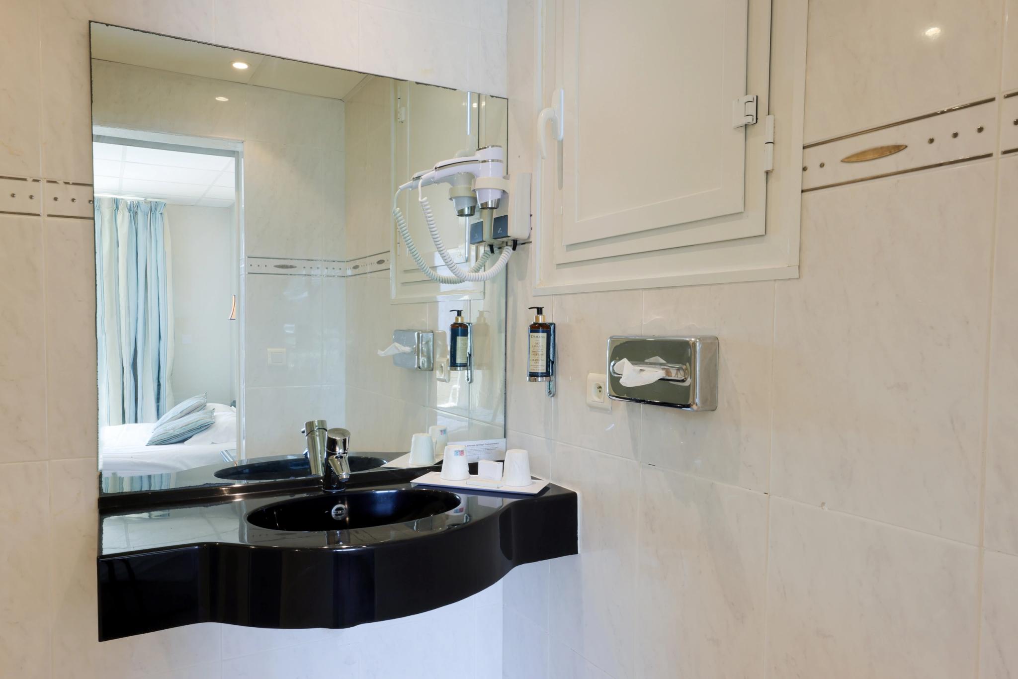 Salle de bain attenante avec douche et vasque dans une chambre Standard avec vue mer à Calvi