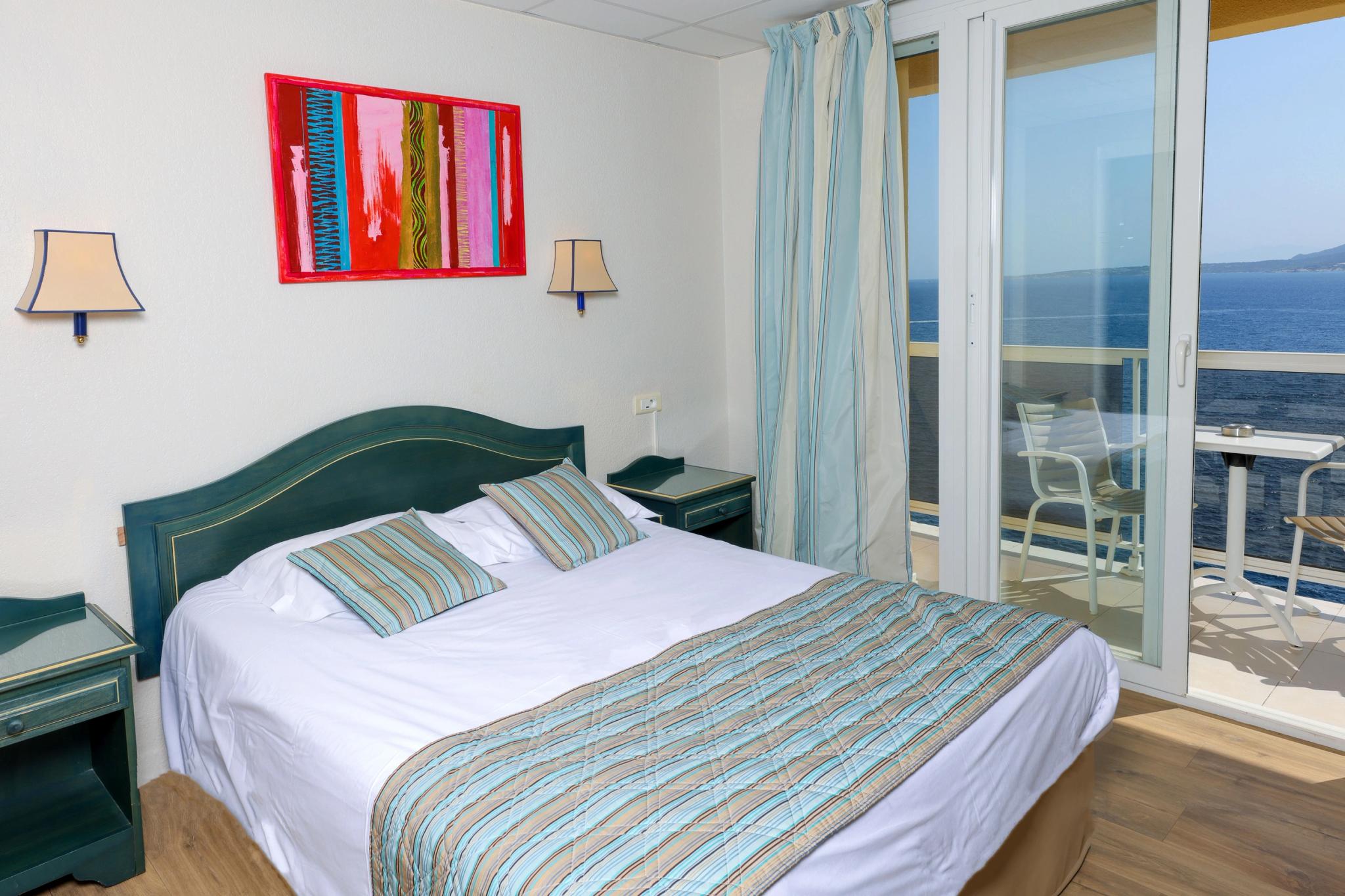 Baie vitrée donnant directement sur la Méditerranée dans une chambre double ou twin à Calvi