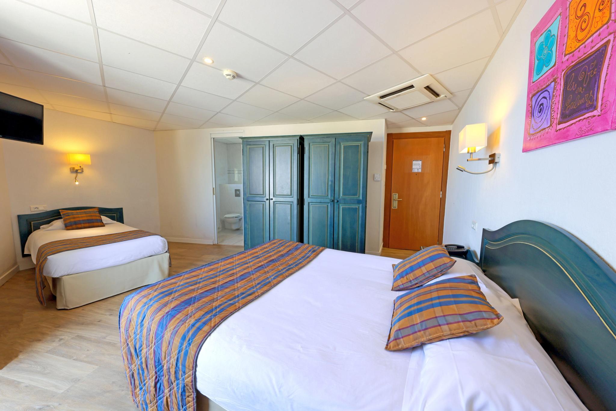 Chambre triple fonctionnelle avec mobilier pratique et vue mer partielle en Haute-Corse