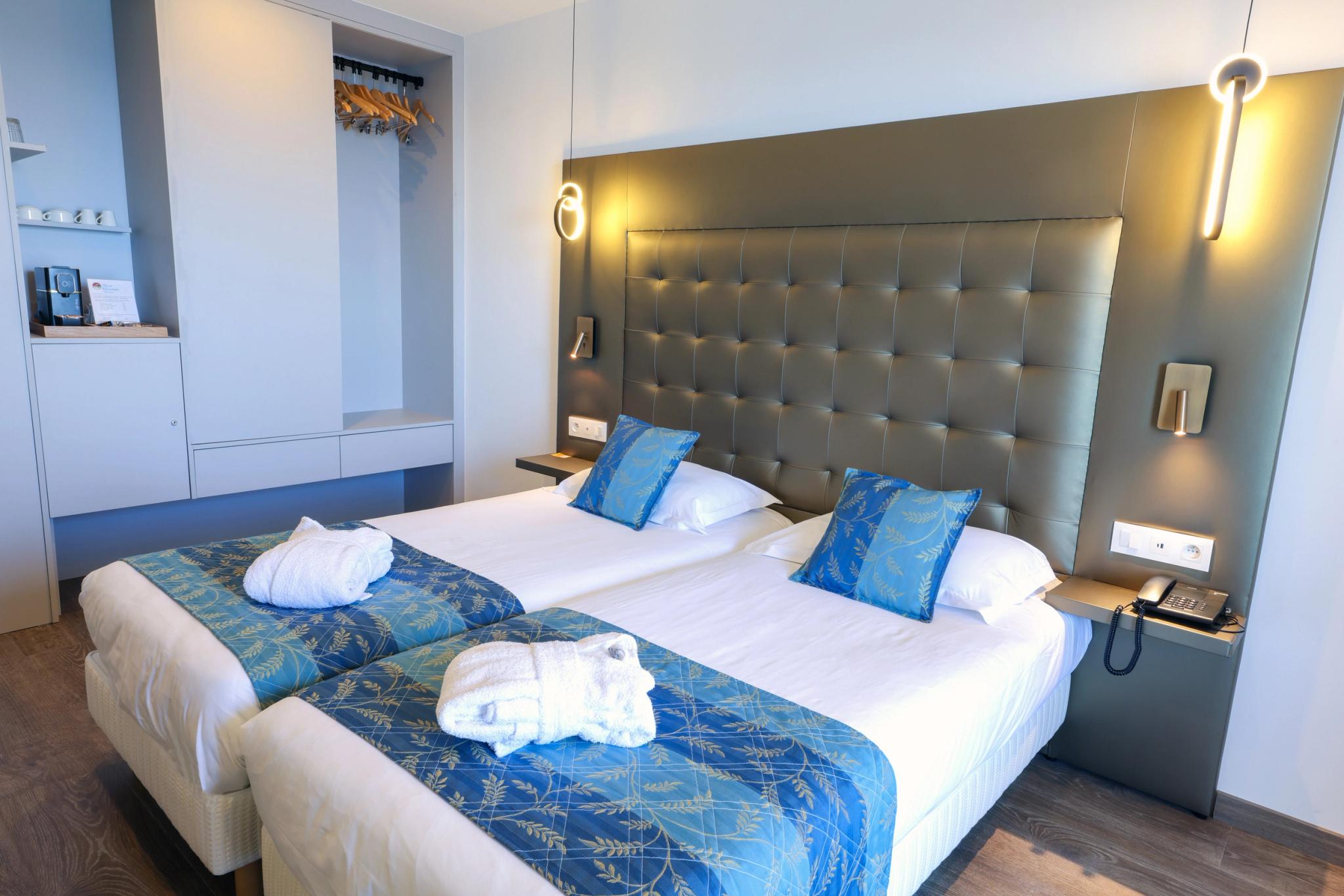 Chambre Supérieure avec deux lits jumeaux et vue partielle sur la mer depuis le balcon