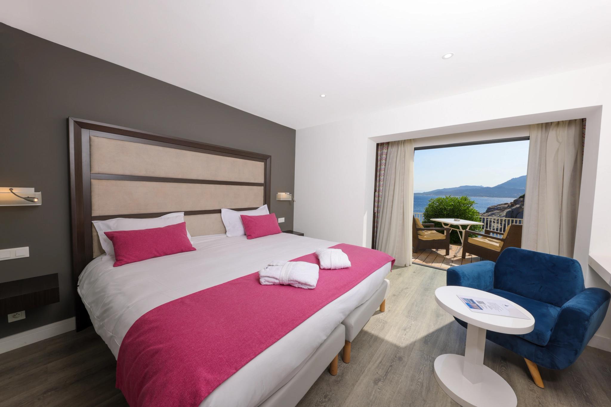 Intérieur soigné d’une chambre Supérieure avec grande baie vitrée donnant sur la mer à l’Hôtel Saint-Christophe
